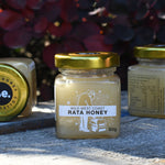 Three jars of honey on a honey box with a blurred natural background